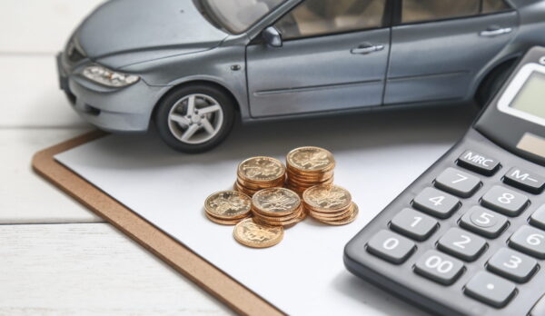 car model,calculator and coins on white table